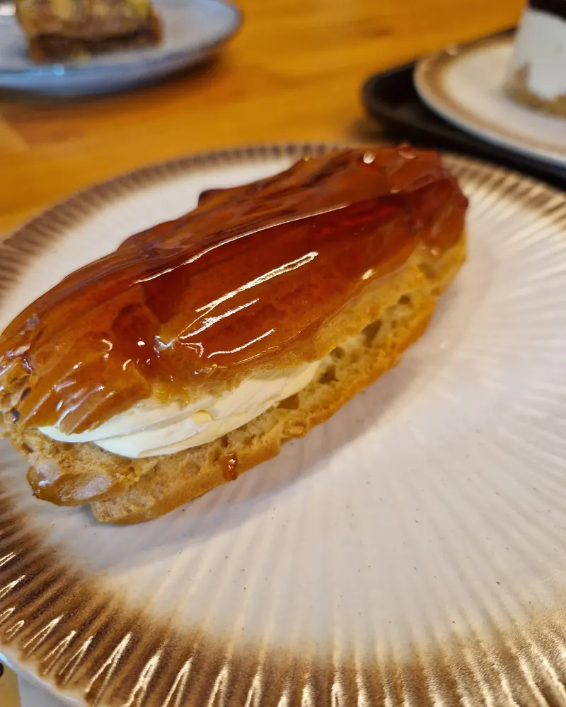 Caramel-glazed eclair filled with cream